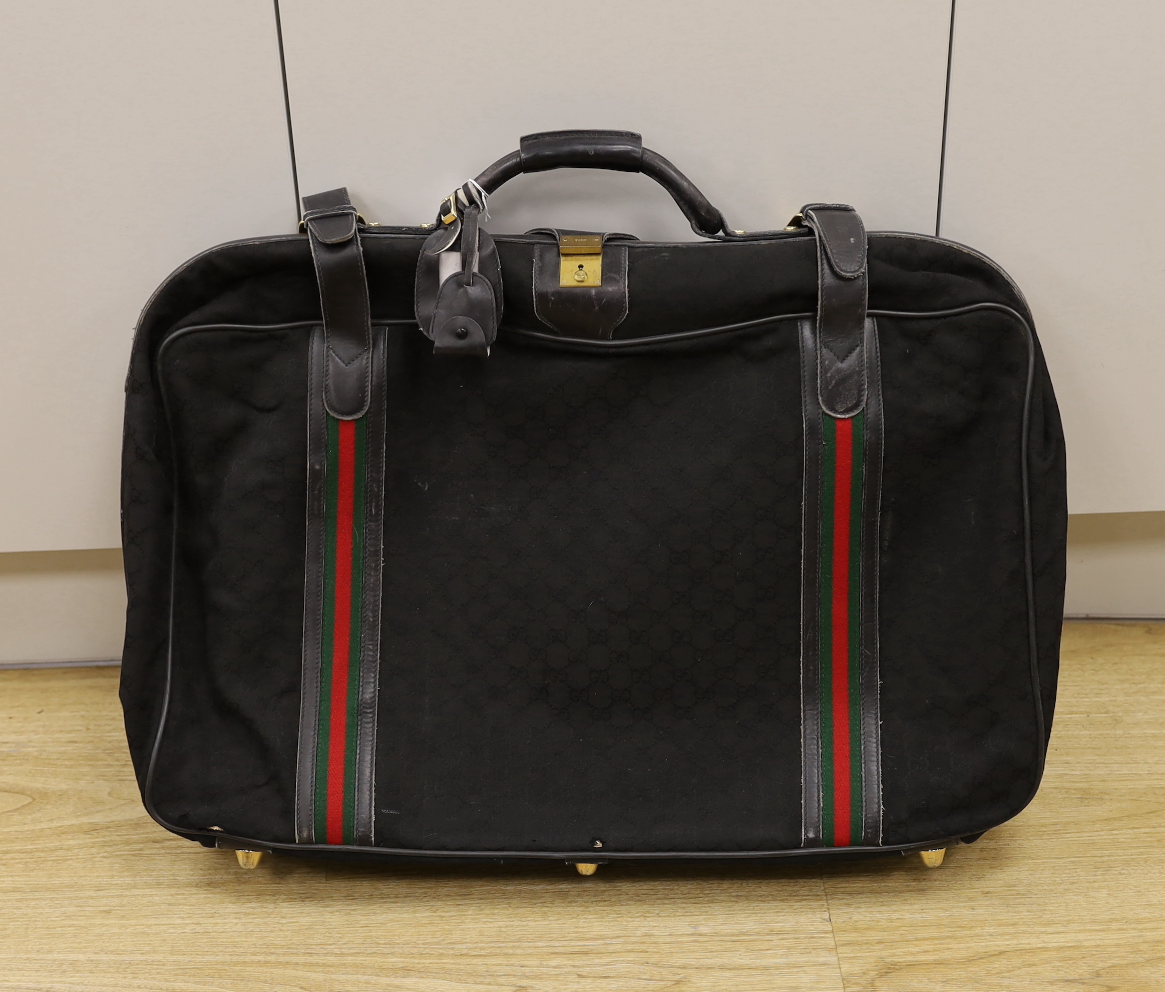 A black fabric and leather trimmed Gucci suitcase